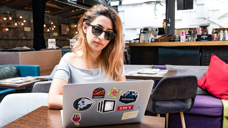 Mujer con gafas trabajando con el portátil